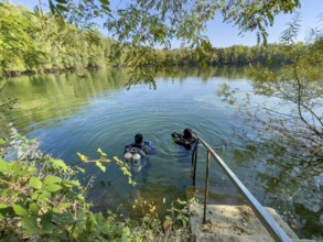Recreational divers with diving equipment Diving tanks swim near the shore on the water surface of