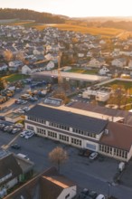 Aerial view of village at sunset with buildings and roads in warm autumn light, Althengstett, Calw