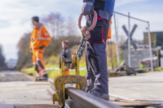 Close-up of a hook on a rail, workers in the background, track construction, Hermann Hesse Railway