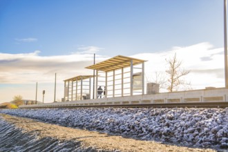 Station platform under blue sky in rural surroundings, new Hermann Hessebahn railway station,
