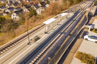 Station environment with platforms and apartments, autumnal atmosphere, drone image with parked