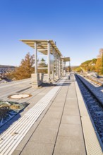 Autumn platform with modern architectural elements under clear skies, new Hermann Hessebahn railway