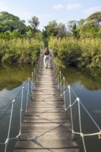 Toruist on the Kavango River, suspension bridge at Camp Kwando, Zambezi region, Caprivi Strip,