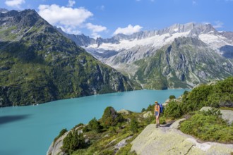 Female mountaineer in front of picturesque mountain landscape, turquoise-blue mountain lake