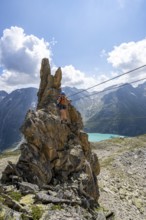Crocodile rock formation, mountaineer on rope bridge in the Crocodile Mountain Lake via ferrata on
