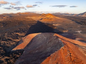 Picturesque volcanic landscape in evening light, red volcano Montaña Bermeja between lava fields,