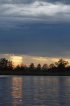Sunset over the river with dramatic clouds, Peenetal nature park Park, Mecklenburg-Western