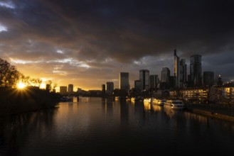 The sun sets behind the Main and bathes Frankfurt's banking skyline in orange-yellow light, Alte