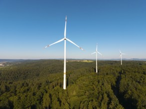 Wind turbines over dense forest stretch into the vastness of the sky, near Schorndorf, Remstal,