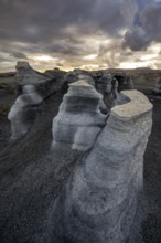Eroded rock formations, volcanic landscape with dramatic cloudy sky at sunset, Ciudad Estratificada