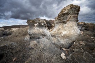 Eroded rock formations in volcanic landscape with dramatic cloudy skies, Ciudad Estratificada or