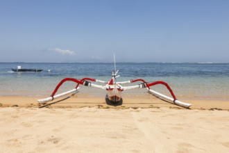 Colourfully painted outrigger fishing boats, (Junkung), on Sanur beach, Bali, Indonesia