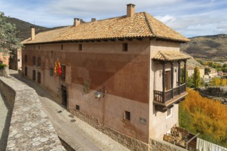 Alberque hostel building with flags flying, historic buildings in medieval village of Albarracín,