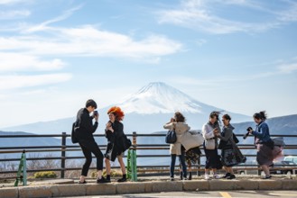 Tourists enjoy the view and take pictures, view of the snow-covered summit of Mount Fuji volcano in