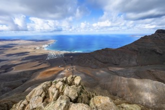 View from the Risco de Famara cliffs to the coast and the sea with the Famara beach, Playa de