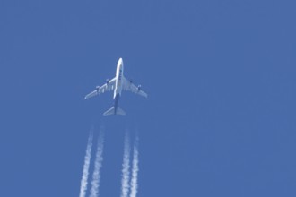 Boeing 747 jumbo jet cargo aircraft of Atlas air airlines flying in a blue sky with contrails or