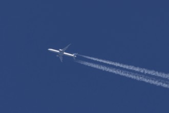 Boeing jet passenger aircraft of United airways airlines flying in a blue sky with contrails or