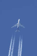 Boeing 747 jumbo jet cargo aircraft of Atlas air airlines flying in a blue sky with contrails or