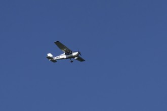 Cessna 172C Skyhawk light aircraft flying in a blue sky, England, United Kingdom