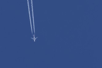 Airbus jet passenger aircraft of Eurowings airlines flying in a blue sky with contrails or vapour