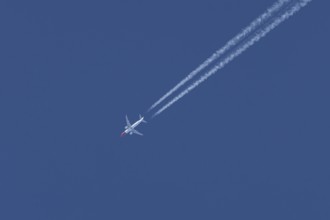 Boeing 737 jet passenger aircraft of Norwegian Air airlines flying in a blue sky with contrails or