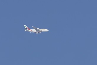 Airbus A380 jet passenger aircraft of Emirates airlines flying in a blue sky, England, United
