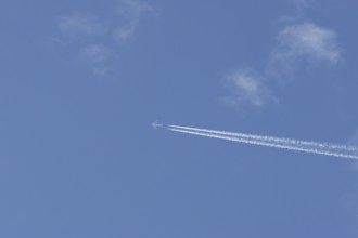 Boeing 737 jet passenger aircraft of Norwegian Air airlines flying in a blue sky with contrails or