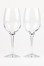 Two elegant, transparent wine glasses with long stems next to each other