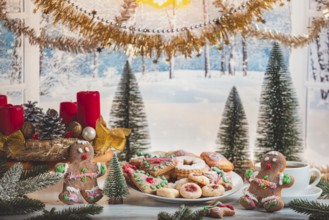 Christmas table with cookies and decorations in front of snow-white landscape