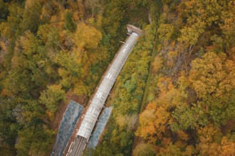 Aerial view of a train tunnel under construction surrounded by autumn trees, Hermann-Hesse-Bahn