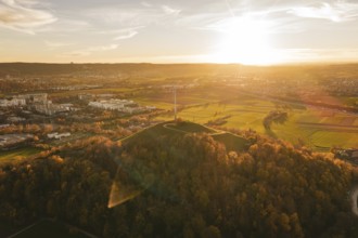 A wide landscape with fields, wind turbine and forest at sunset, Grüner Heiner, Korntal, Germany
