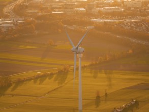 Close-up of a wind turbine standing over fields in the evening sun, Grüner Heiner, Korntal, Germany