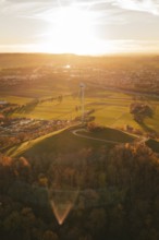 A wind turbine overlooks a vast, autumnal landscape at sunset, Grüner Heiner, Korntal, Germany