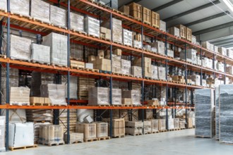 Industrial warehouse storing countless boxes, pallets, and goods wrapped in plastic on multiple