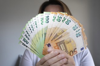 Human hand with several 50 and 100 euro banknotes