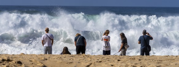 Tourists watch the waves of the Atlantic on the rocky plateau of Sito, also known as Forte São