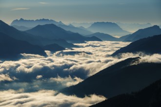 Blue-colored silhouette of mountains, fog in the valley, Wilder Kaiser and Chiemgau Alps, Upper