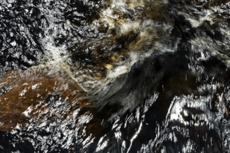 Stream flow with dark water, reflections and turbulences, long exposure, Sweden