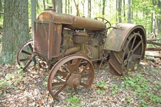 Rusted American Fordson tractor with iron tires around 1900, deposited in a wooded area, Marksboro,