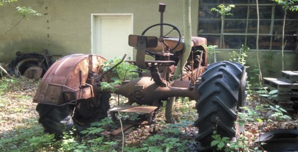 Rusted tractor at a car cemetery in a forest, Marksboro, New Jersey, USA