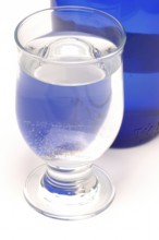 Glass with mineral water, small carbonated pearls on the edge of the glass, drinking water
