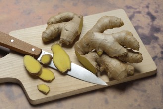 Ginger, ginger root cut with ginger slices on wooden boards