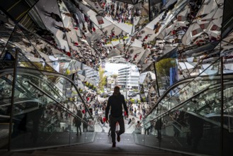 Young man on a stairway, entrance to a shopping center with many mirrors, Tokyu Plaza Omotesando