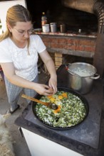 Serbian woman cooking przeno or traditional Serbian dish in her kitchen, Vrmdza, Sokobanja, Serbia