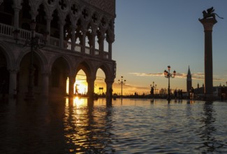 View through the arcades of the Doge's Palace at sunrise on Piazzetta during Acqua Alta, Venice,