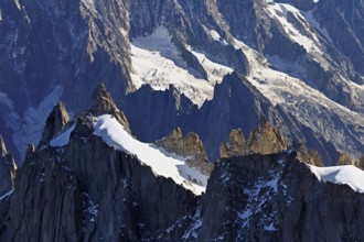 Rugged rocks jut out of a snow-covered mountain, viewing platform, Aiguille du Midi mountain