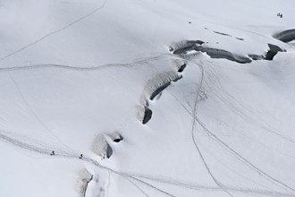 A group of mountaineers runs across a snow-covered mountain, Aiguille du Midi, Chamonix-Mont-Blanc,
