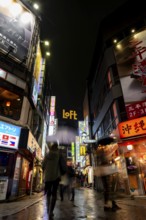 Busy pedestrian zone with many shopping centers and stores, illuminated with lots of neon signs at