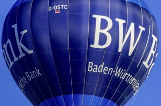 A hot air balloon, registration D-OSTC, rises into the air as part of an air show at the Rossfeld