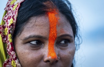 A Hindu devotee offer prayers to the Sun God on the bank of Brahmaputra river on the occasion of